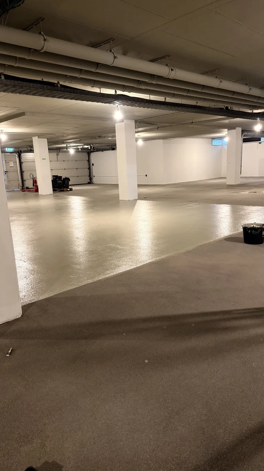 Aangebrachte vloercoating naast een volgend werkvak in de parkeergarage