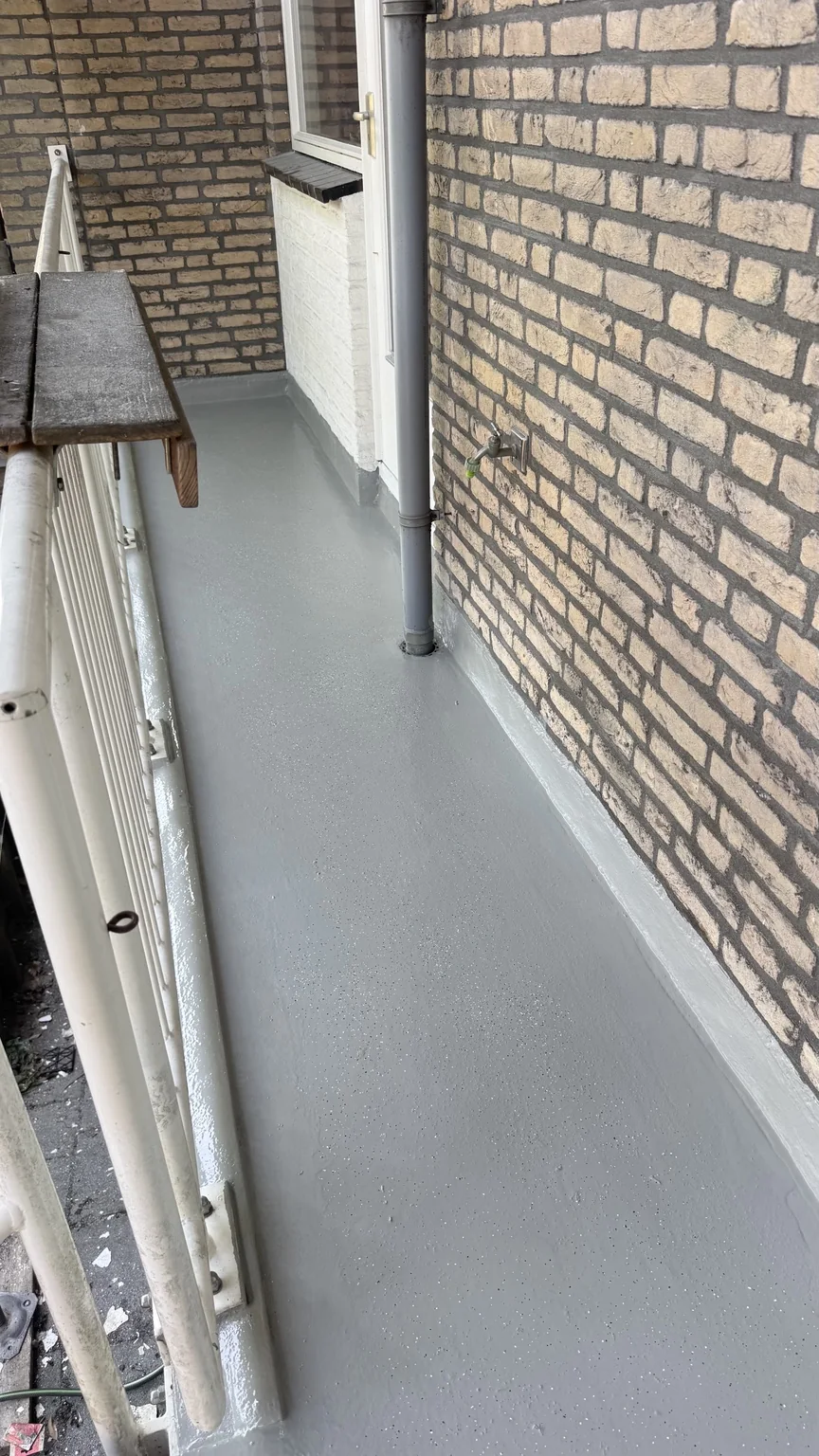 Detail van de ALSAN-afwerking langs opstanden en een regenpijp