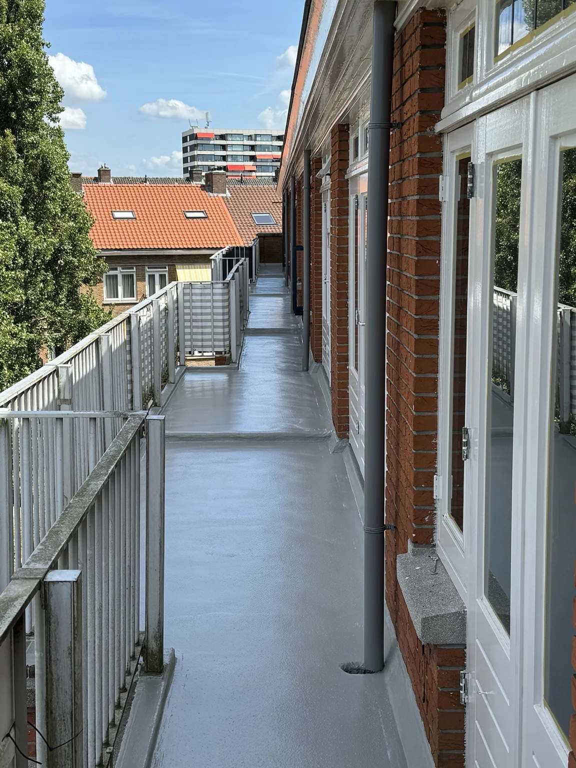 Gerenoveerde balkons met grijze afwerking langs de bakstenen gevel — VvE Rotterdam Blijdorp