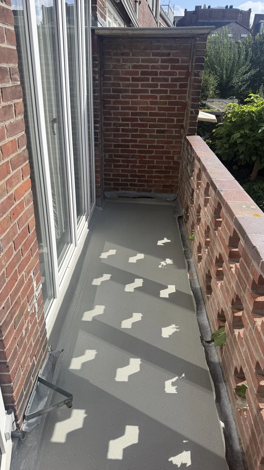 Balkon in Utrecht met grijze ALSAN Balkon Easy-afwerking langs een bakstenen gevel