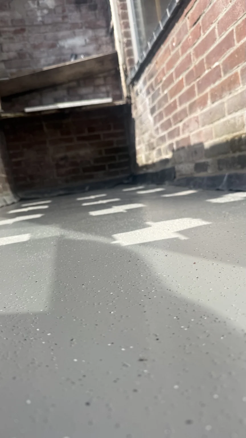 Detail van de afgewerkte balkonvloer bij de gemetselde opstand